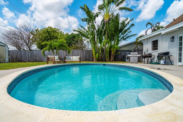 view of swimming pool with a patio area, outdoor lounge area, a fenced backyard, and a fenced in pool