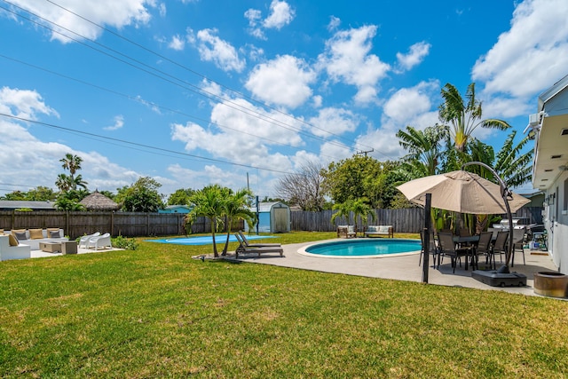 view of swimming pool featuring a storage shed, a fenced backyard, an outdoor hangout area, a yard, and a patio area