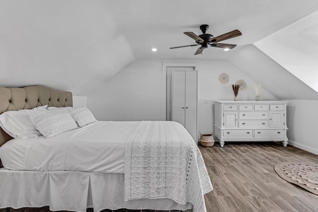 bedroom featuring lofted ceiling, a ceiling fan, baseboards, and wood finished floors