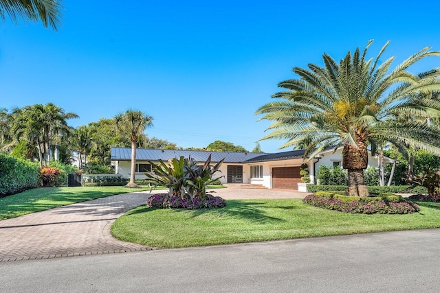 single story home featuring a garage and a front yard