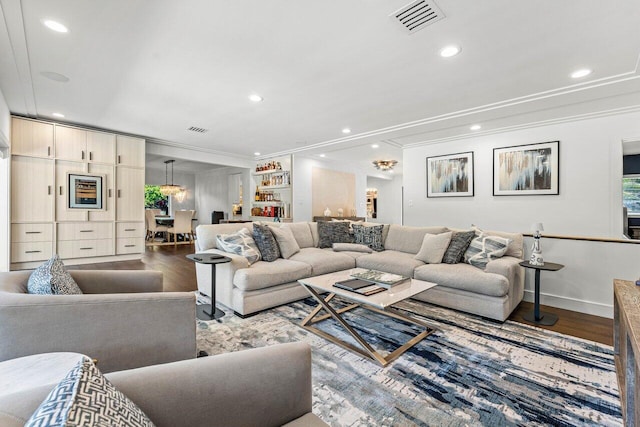 living room with wood-type flooring and ornamental molding