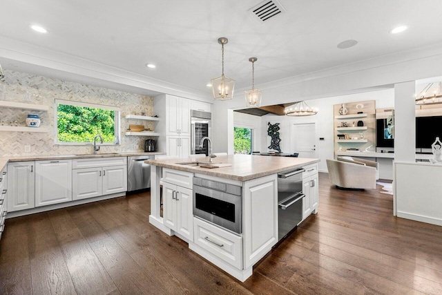 kitchen featuring white cabinetry, sink, dishwasher, and a center island with sink