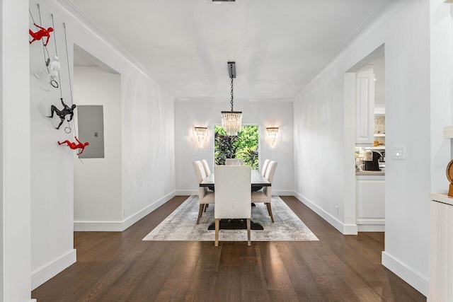 dining room featuring ornamental molding, electric panel, dark wood-type flooring, and a notable chandelier