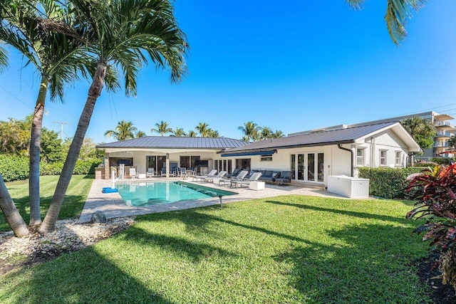 rear view of house with french doors, a yard, and a patio area