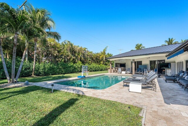 view of pool with a lawn, outdoor lounge area, ceiling fan, and a patio