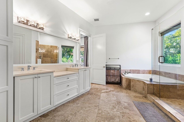 bathroom with plenty of natural light, vanity, and plus walk in shower