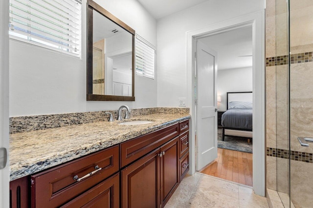 bathroom with a shower with door and vanity