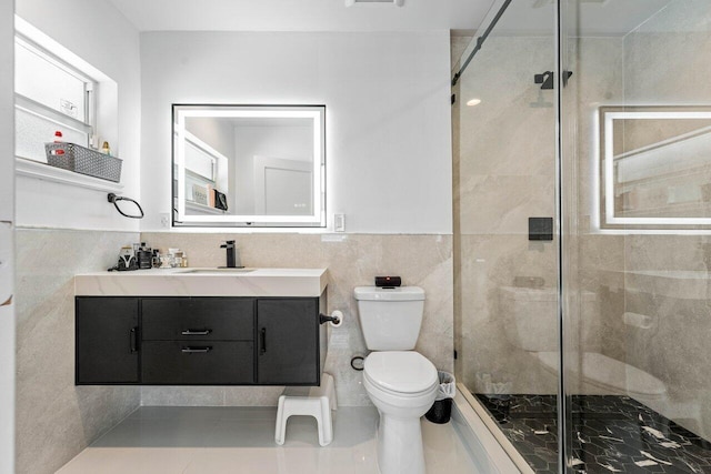 bathroom with vanity, tile patterned floors, toilet, tile walls, and walk in shower