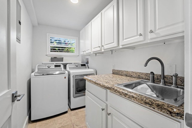 laundry area featuring cabinets, washing machine and dryer, and sink