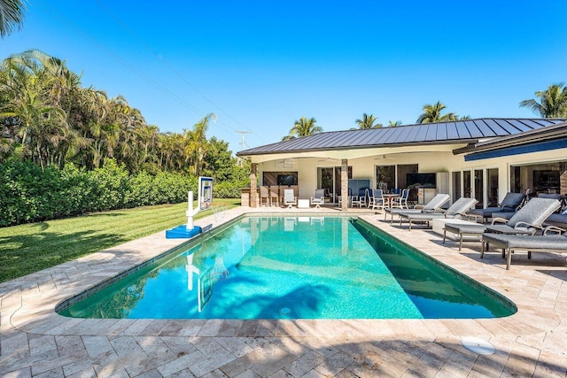 view of pool with ceiling fan, exterior bar, and a patio