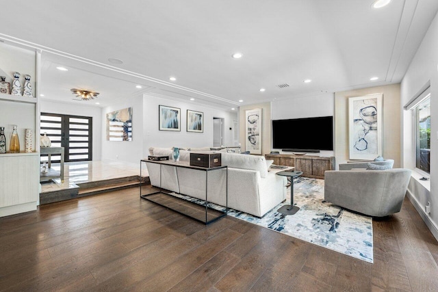 living room with dark hardwood / wood-style flooring and ornamental molding