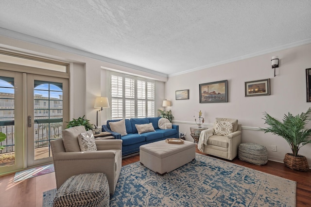 living room featuring dark hardwood / wood-style floors, plenty of natural light, ornamental molding, and a textured ceiling