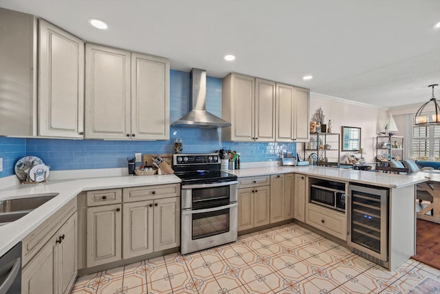 kitchen with appliances with stainless steel finishes, tasteful backsplash, beverage cooler, wall chimney range hood, and decorative light fixtures