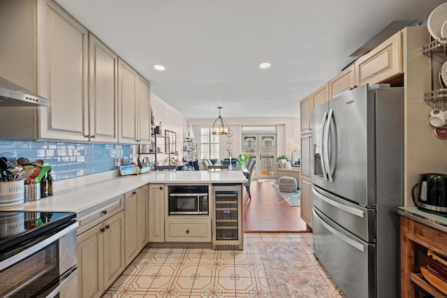 kitchen with stainless steel appliances, wine cooler, kitchen peninsula, decorative light fixtures, and cream cabinetry