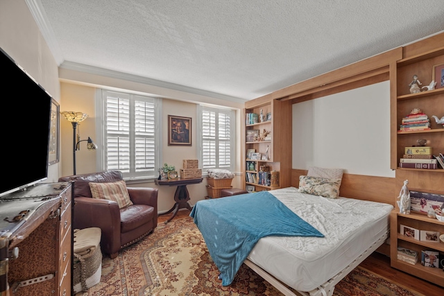 bedroom with hardwood / wood-style floors, a textured ceiling, and ornamental molding