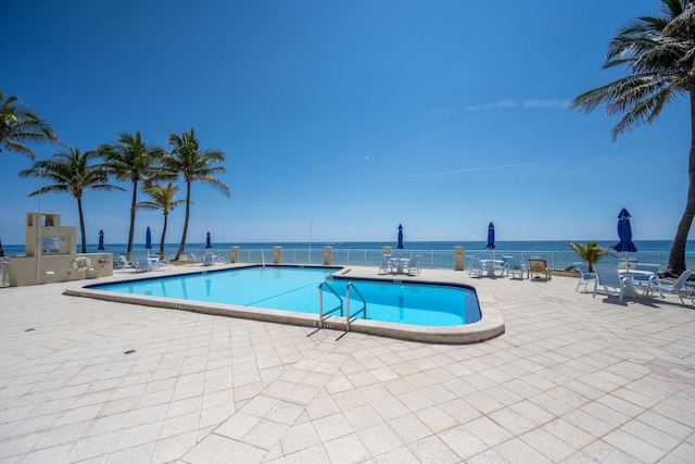 view of pool with a water view and a patio area