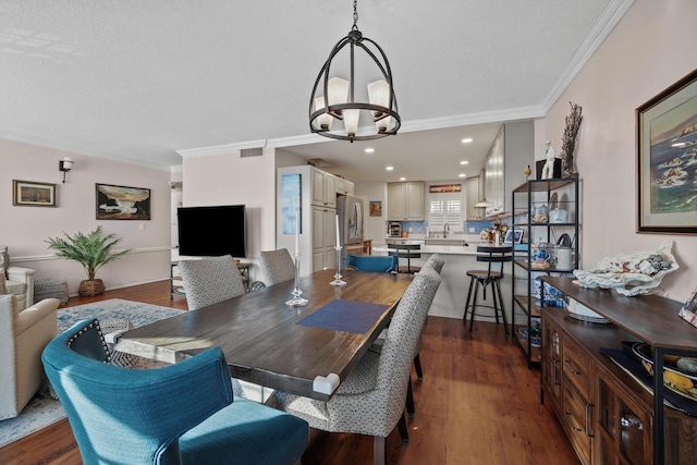 dining space featuring dark hardwood / wood-style flooring, an inviting chandelier, and crown molding