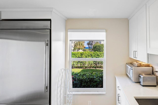 interior space featuring white cabinetry and fridge