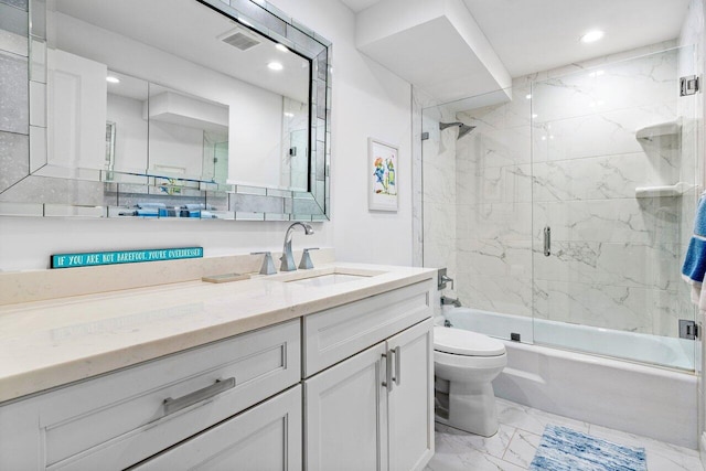 full bathroom featuring vanity, shower / bath combination with glass door, and toilet