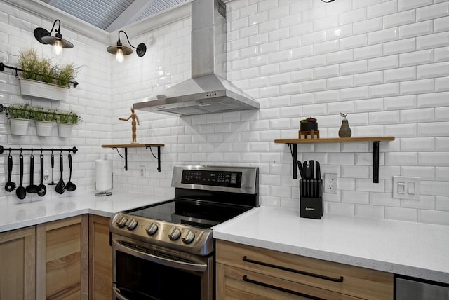 kitchen featuring electric range, tasteful backsplash, and wall chimney range hood