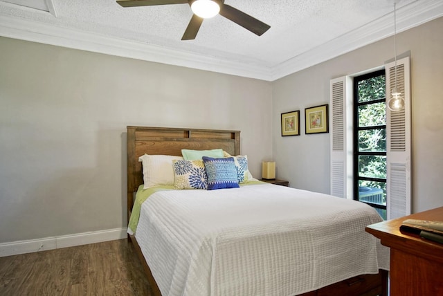 bedroom featuring dark hardwood / wood-style flooring, a textured ceiling, ceiling fan, and ornamental molding