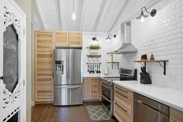 kitchen featuring pendant lighting, light brown cabinets, wall chimney exhaust hood, and stainless steel appliances