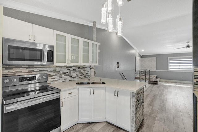 kitchen with white cabinetry, ornamental molding, and stainless steel appliances