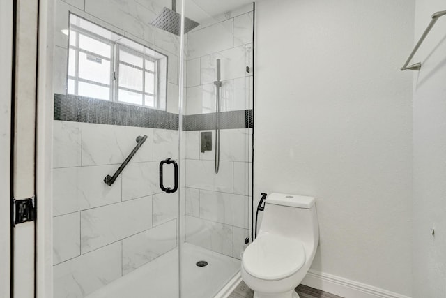 bathroom with toilet and a shower with shower door