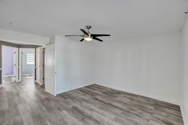 empty room with ceiling fan and light hardwood / wood-style flooring