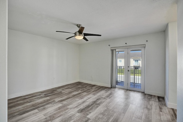 empty room with ceiling fan, french doors, light hardwood / wood-style floors, and a textured ceiling