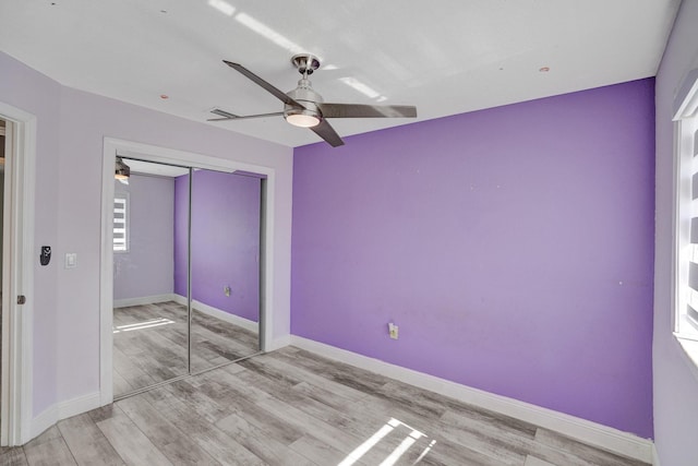 unfurnished bedroom featuring ceiling fan, a closet, and light hardwood / wood-style floors