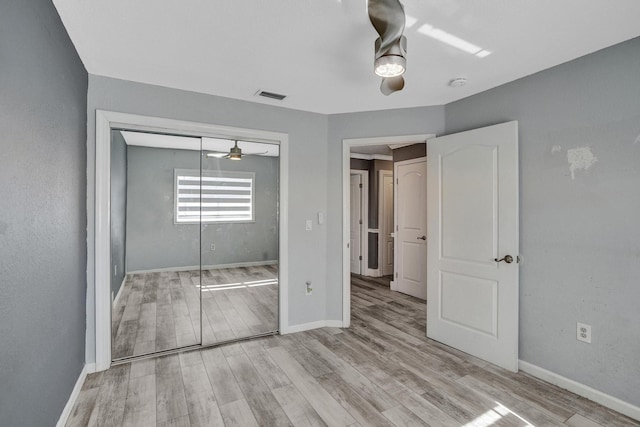 unfurnished bedroom featuring light wood-type flooring, a closet, and ceiling fan