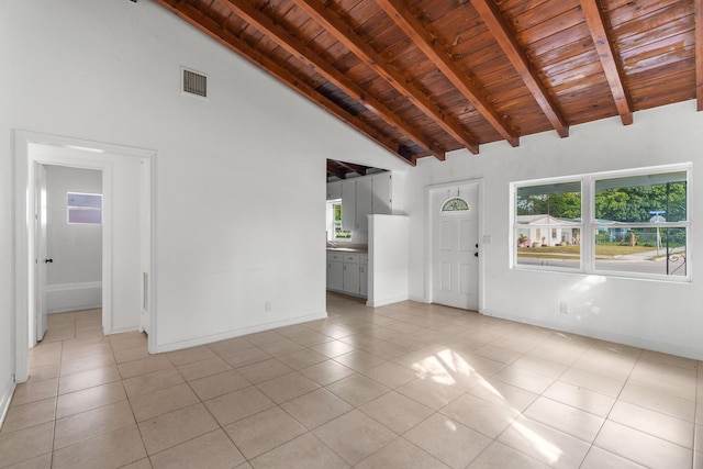 unfurnished living room featuring beamed ceiling, high vaulted ceiling, wood ceiling, and light tile patterned floors