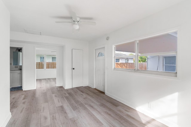 unfurnished room featuring plenty of natural light, ceiling fan, and light hardwood / wood-style flooring