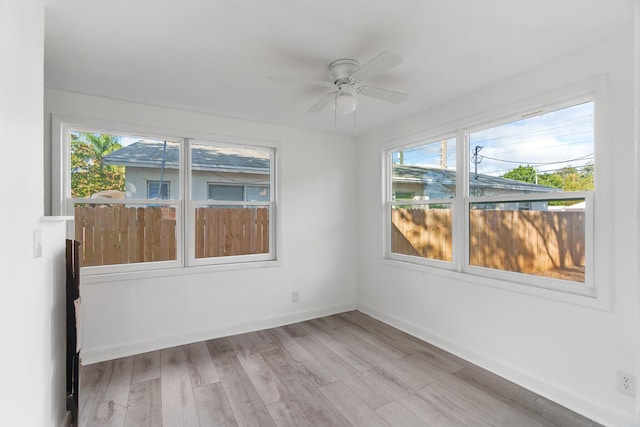 unfurnished room with ceiling fan, wood-type flooring, and a wealth of natural light