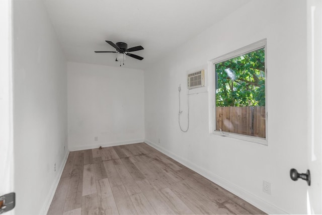 empty room with an AC wall unit, ceiling fan, and light hardwood / wood-style floors