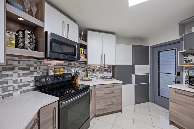 kitchen with electric range, white cabinetry, backsplash, and light tile patterned floors