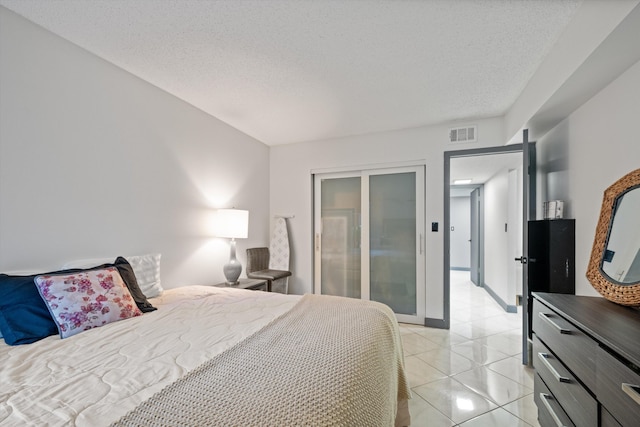 bedroom featuring light tile patterned floors and a textured ceiling