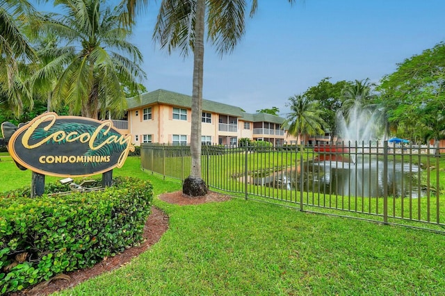 view of home's community with a water view and a lawn