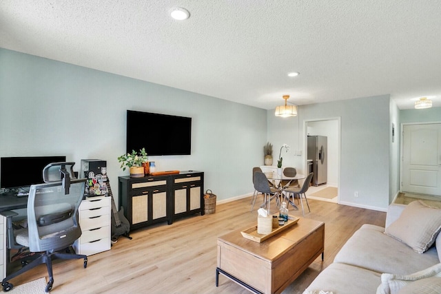 living room featuring light hardwood / wood-style flooring and a textured ceiling