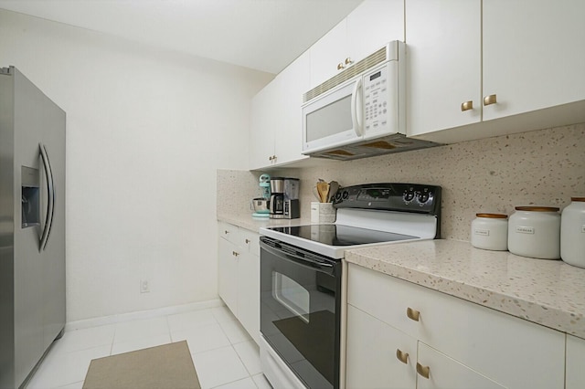 kitchen featuring white appliances, white cabinets, decorative backsplash, light tile patterned floors, and light stone counters