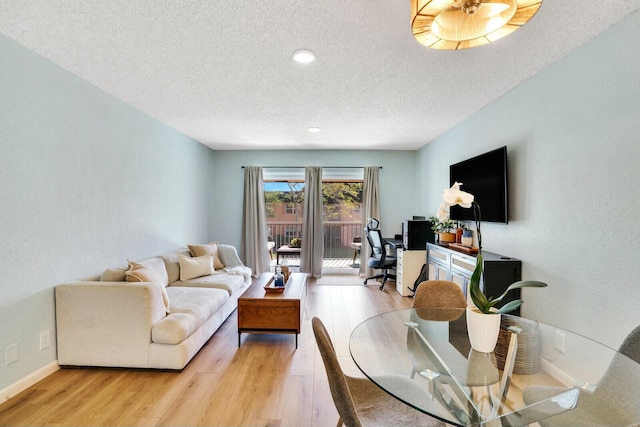 living room featuring a textured ceiling and light wood-type flooring