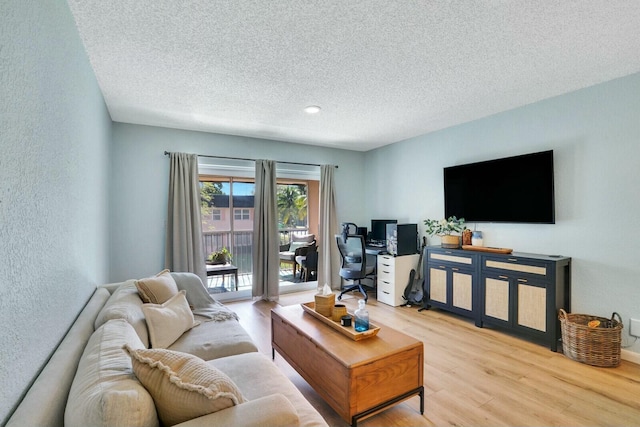 living room featuring light hardwood / wood-style flooring and a textured ceiling