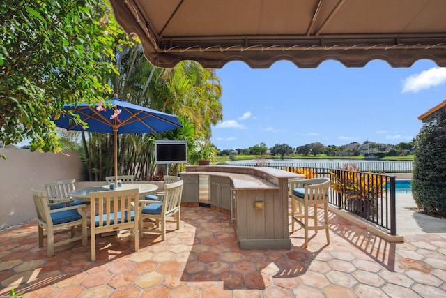 view of patio with exterior kitchen and an outdoor bar