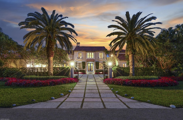 mediterranean / spanish home featuring a lawn