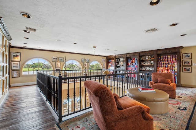 interior space with ornamental molding, hardwood / wood-style floors, and a textured ceiling