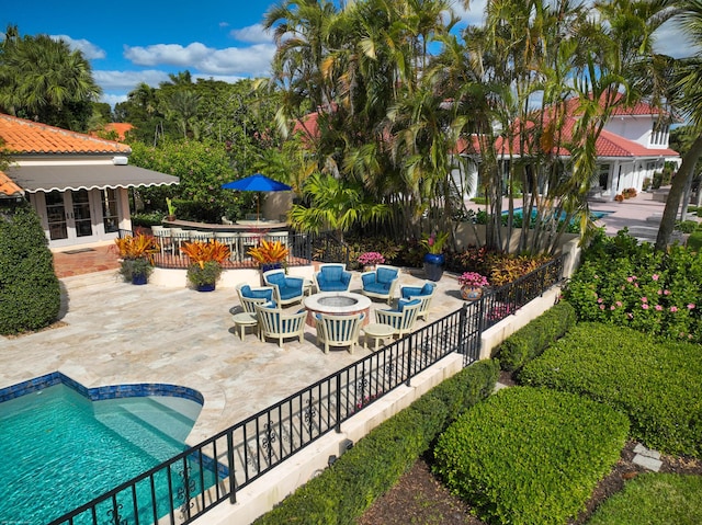 view of pool featuring french doors, a fire pit, and a patio