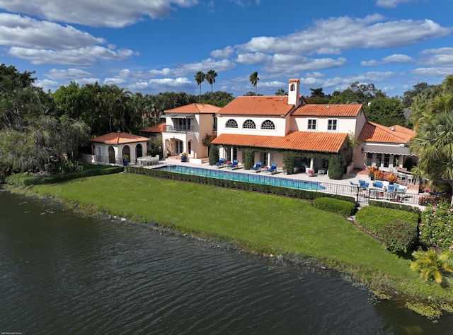 rear view of property featuring a patio, a water view, and a yard