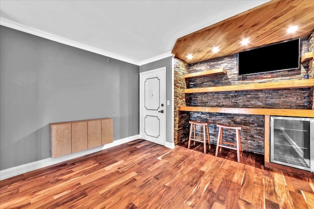 bar featuring wood-type flooring, beverage cooler, and crown molding