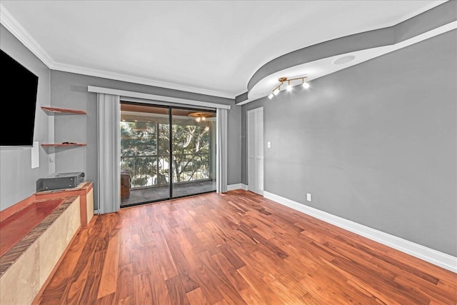 unfurnished living room featuring hardwood / wood-style flooring and crown molding